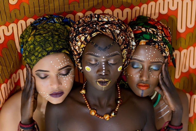Tri ženy s namaľovanými tvárami a náhrdelníkom na krku.jpg